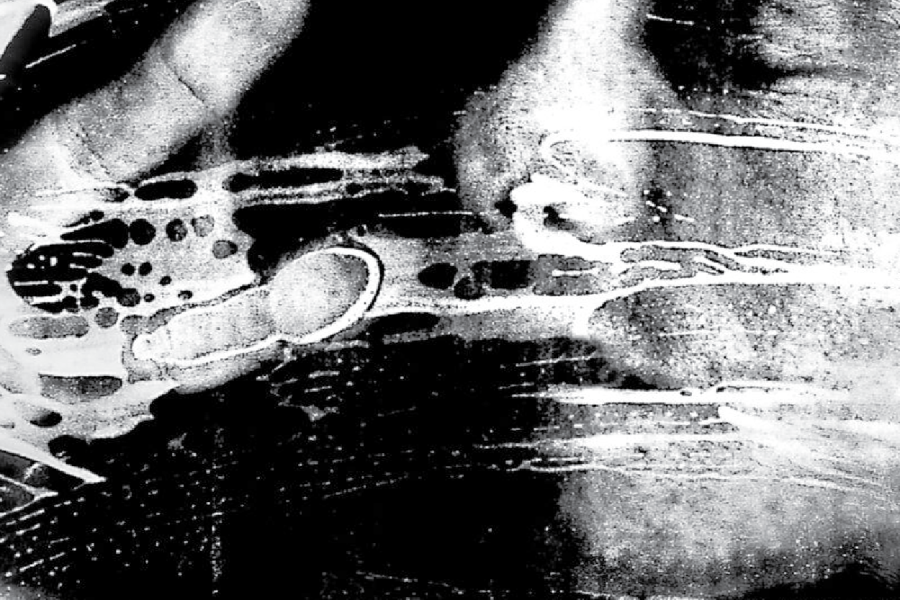 Black and white image of a person's face and hand pressed against glass.