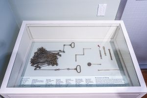 Photo of a gallery case with a few antique surveyors tools