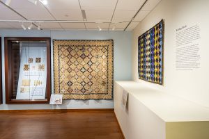 Photo of quilts hanging on gallery walls.