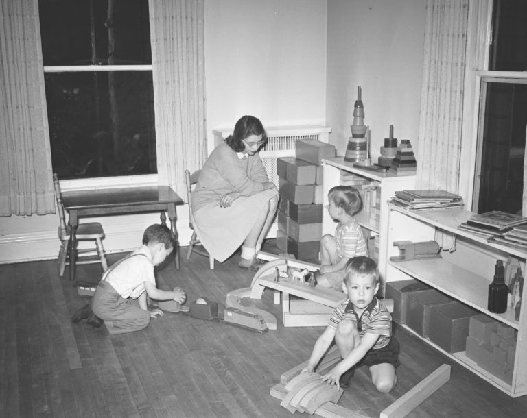 "An unidentified individual, likely a student, working with children in the nursery school." Human Ecology Collection ca. 1930